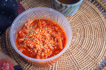 Traditional Korean dishes (Kimchi) in a bowl on rattan pacemat.
