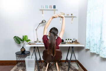 Asian woman working with laptop and document in living room remotely or work from home concept