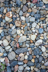 small multi-colored pebbles texture background. colorful stones. vertical photo
