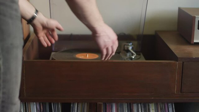 Vinyl record gets flipped on a vintage stereo while listening to music