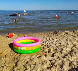Obraz premium Colorful inflatable round pool on the sandy beach of the sea