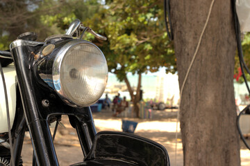 Antique motorcycle headlight at the beach