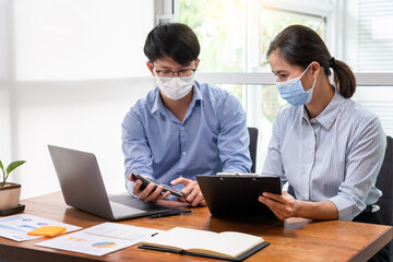 Fototapeta na wymiar Group of Teamwork Asian business People Wearing Protective face Mask In Office During Pandemic coronavirus COVID-19, New Normal and Social distancing concept