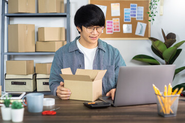 Asian business man startup SME entrepreneur working in a cardboard box prepares delivery box for customer