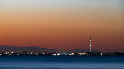 夕焼けを背景に千葉舞浜から東京湾越しに見た東京と山々