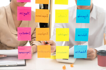 business people planning startup project placing sticky notes session to share idea or brainstorm
