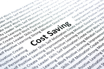 Fototapeta premium Cost saving word on paper with blurred other related words. For strategy and business concept idea.