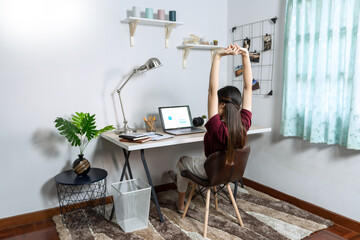 Asian woman working with laptop and document in living room remotely or work from home concept