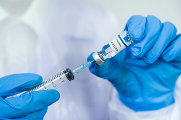 Doctor or scientist in protective suit with clinical injection trials  covid-19 coronavirus vaccination