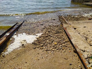Rocky sea shore with a pier and metal constraction