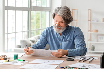 Senior male calligraphist working in office