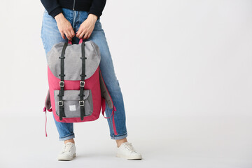 Young woman with backpack on white background