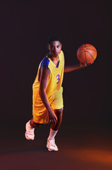 Naklejka premium Young African-American basketball player on dark background