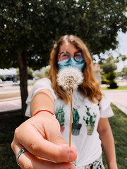 Hermosa mujer sostiene un diente de le&oacute;n