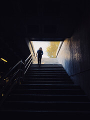 Joven mujer sube las escaleras de un estacionamiento subterráneo