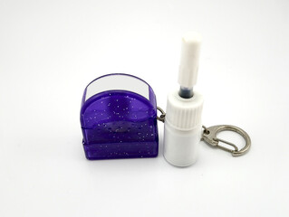 Liquid black refill ink placed in small white plastic bottle and Small purple plastic glitters stamp with metal key ring