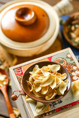 Dried lilies on a plate in front of a casserole background