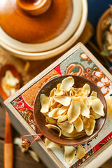 Dried lilies on a plate in front of a casserole background