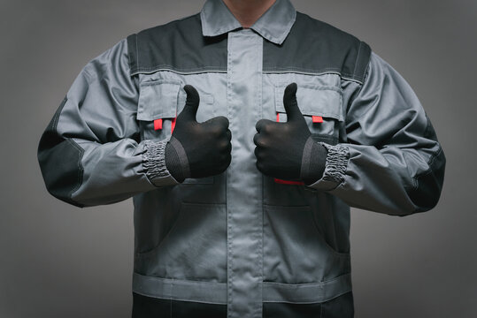 The worker is showing a thumbs up gesture close up.