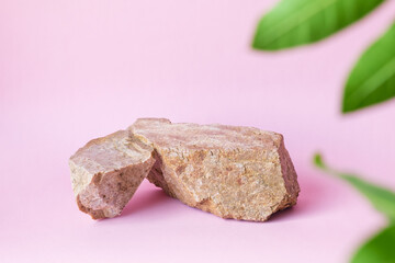 natural stones green leaves on a pastel pink background, space for product branding mockup