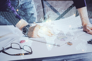 Double exposure of Man writing in notepad with business icons on background.