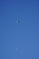 東京の空に月と飛行機