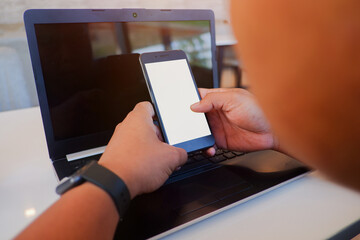 Cropped shot view of man’s Hands hold the smartphone with blank copy space screen for your information content or text message on the gray granite at the modern place.