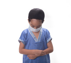 A muslim child,male,wearing face mask,performing act of prayer