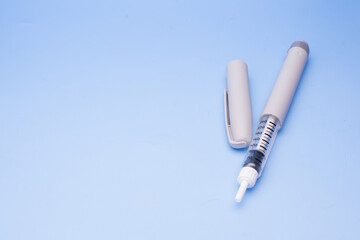 Insulin pen isolated over blue background
