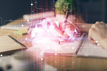 Multi exposure of writing hand on background with brain hologram. Concept of self learning.