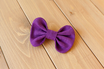Purple background for a greeting card: a satin ribbon bow - at the top, on the left.