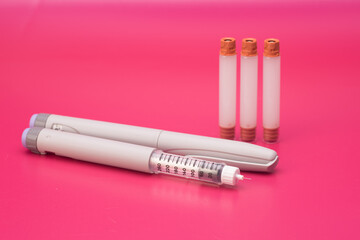 Insulin pen and cartridge over red background