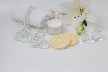 Obraz na płótnie Canvas Lily (Lilium candidum) face cream with white towel, peals, Lilium fresh flower and sponges, isolated white