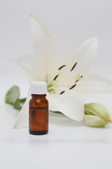 Obraz na płótnie Canvas Lily (Lilium candidum) essential oil bottle on Lilium fresh flower background, isolated white