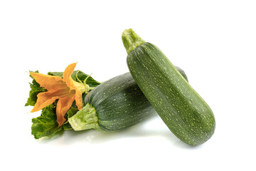 fresh zucchini with green leaves and flower isolated on a white background