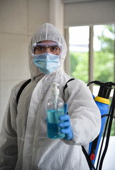 Fototapeta na wymiar A man in protection germ suit or PPE suit with Equipment Face shield, Mask, and Alcohol gel for cleaning place and fighting Corona virus (covid 19) outbreak quarantine/disinfection