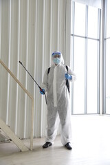 A man in protection germ suit or PPE suit with Equipment Face shield, Mask, and Alcohol gel for cleaning place and fighting Corona virus (covid 19) outbreak quarantine/disinfection