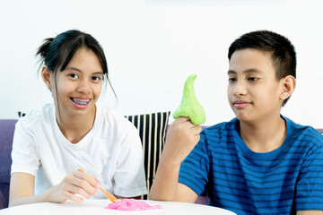 Boy and Girl Sibling Hand Holding Homemade Toy Called Slime, Kids having fun and being creative by science experiment. Selective focus on Slime. Selective focus on Slime.