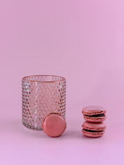 Creative minimalistic composition with macarons and vase. Funky food concept on light pink background.