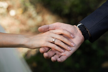 bride and groom holding hands. wedding rings