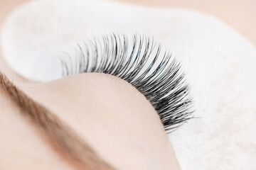 Woman master making fake long lash Eyelash extension procedure