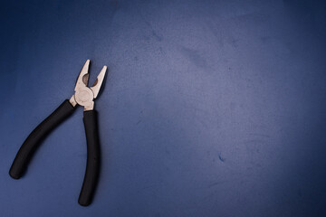 A pliers isolated over blue surface