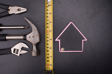 Set of tools with a house symbol,over wooden background