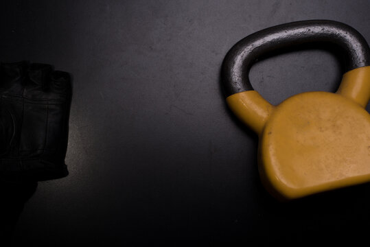 A used yellow kettle bell isolated over dark background,high angle shot