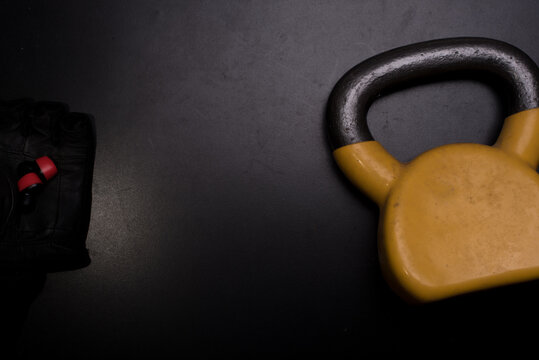 A used yellow kettle bell isolated over dark background,high angle shot