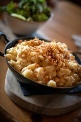 Käsespätzle - typisch regionales Essen, rustikal serviert in einer gußeisernen Pfanne