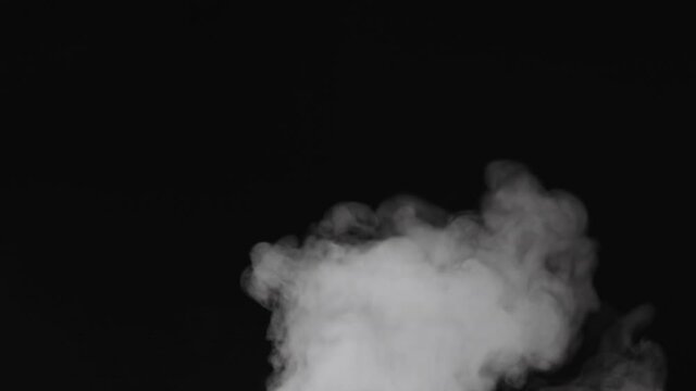 Slow motion water mist puff cloud over black background