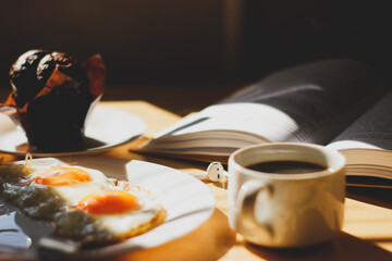 Fototapeta na wymiar breakfast on the table coffee fried eggs and ripe cherries in the sunlight