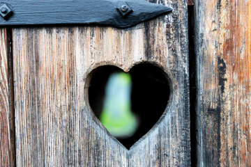 Old wooden door of a toilet with heart shape	