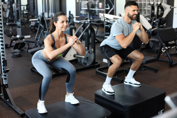 Fototapeta na wymiar Fit couple doing jumping squats in crossfit gym.